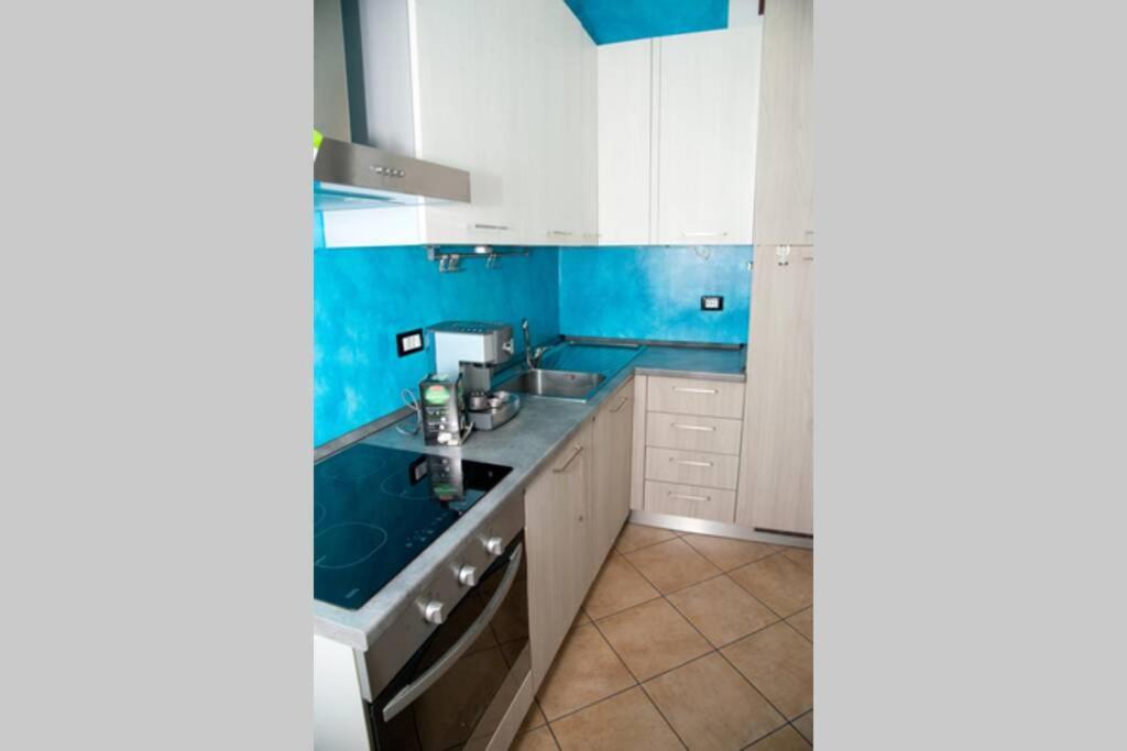 奥瓦达La Casa Di MIK的厨房配有白色橱柜和蓝色的墙壁