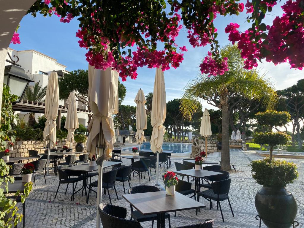 阿尔布费拉Algarve Luxury Experience - Situated within the Pinecliffs Resort的一组桌椅和遮阳伞