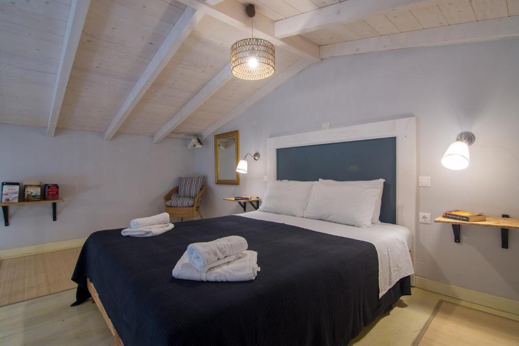 盖奥斯Villa Elaia Suites & Apartments No.7的一间卧室配有一张大床和毛巾