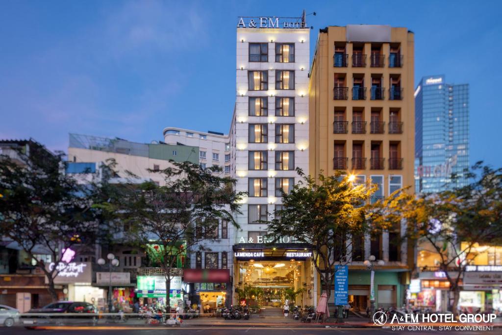 胡志明市A&EM潘伯舟路酒店的一座高大的白色建筑,在城市里,有树木