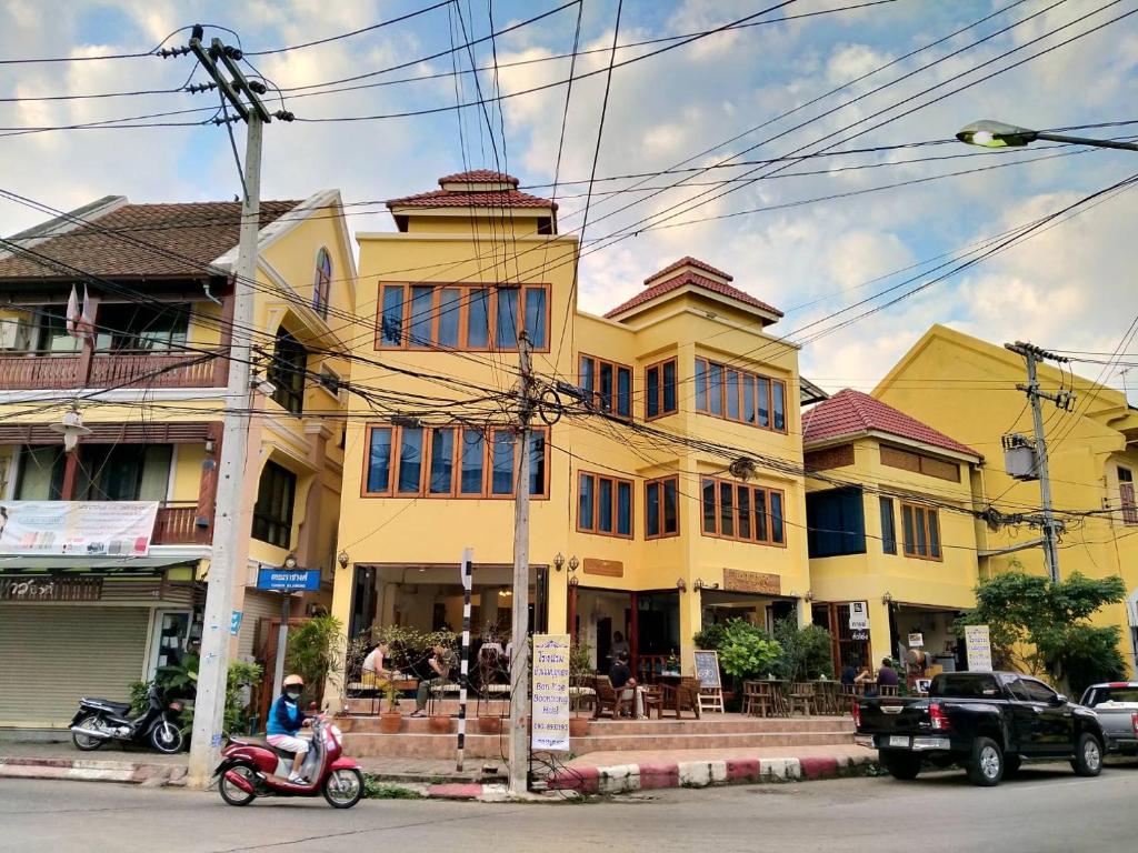 南邦Ban Mae Boonthong的门前有一辆滑板车的黄色房子