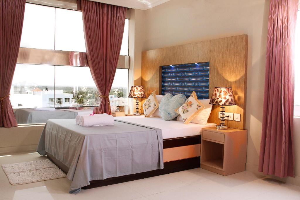 根尼亚古马里Hotel Skyark的一间卧室设有一张床和两个窗户。