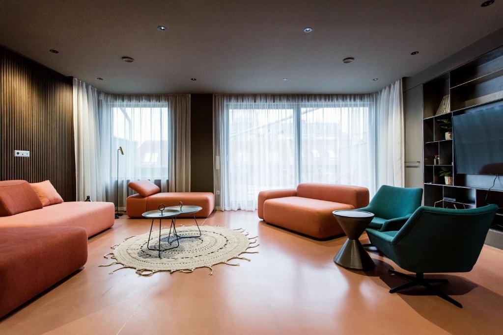 布达佩斯K52 luxury 4BDRM 4BTHRM apartment的客厅配有橙色家具和绿色椅子