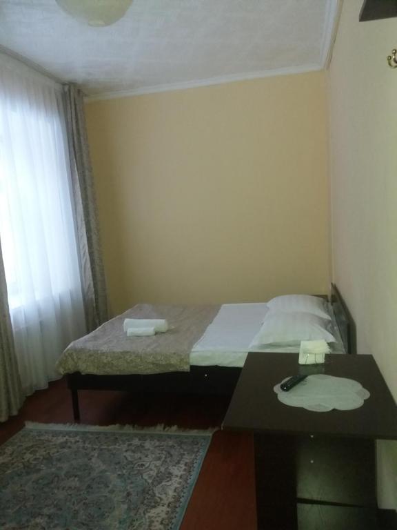 塞米伊Гостиница "SEMEY-CITY"的小房间设有一张床和一张桌子