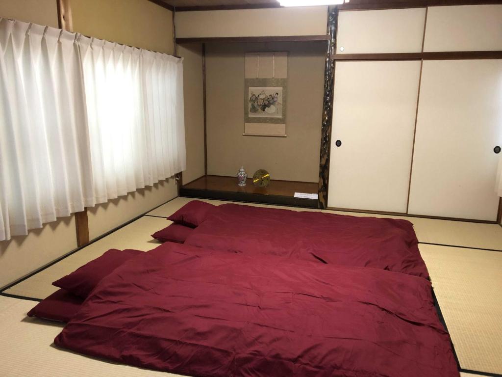 IwatakiGINGAYA的窗户客房内的一张红色大床
