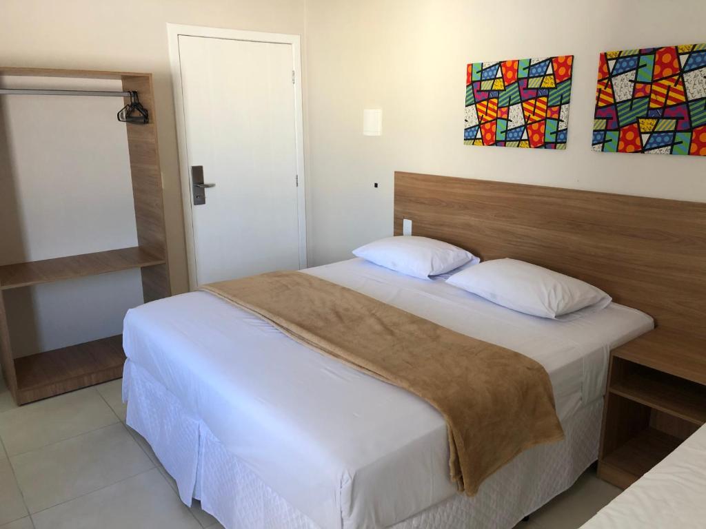泰谢拉迪弗雷塔斯Hotel QualitySul的一间卧室配有一张大床和木制床头板