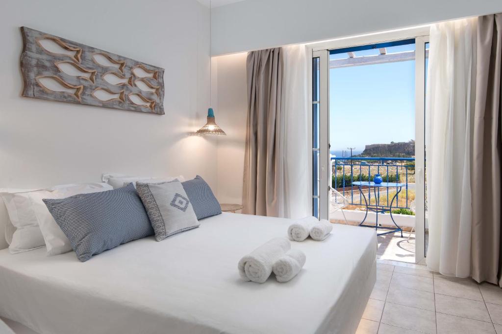 林都斯‘林德斯神话’海景一室公寓酒店的卧室配有白色床和毛巾