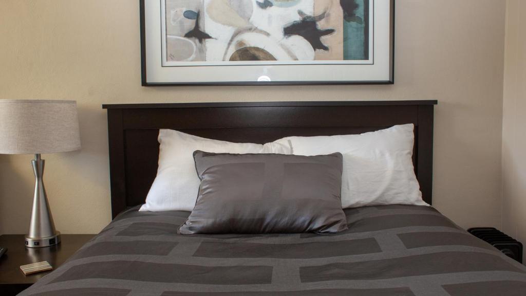 ScottdaleMark III, INN & Suites的一张带枕头的床和墙上的照片