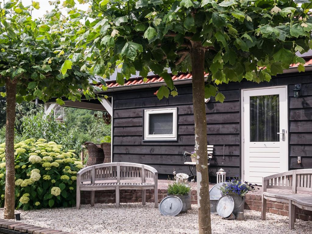 NumansdorpBed & Breakfast De Schuur Inn的小木屋前的2张长椅