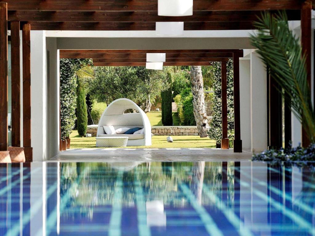 索维拉索维拉莫加多尔索菲特高尔夫酒店及水疗中心的房屋内一个带沙发和椅子的游泳池