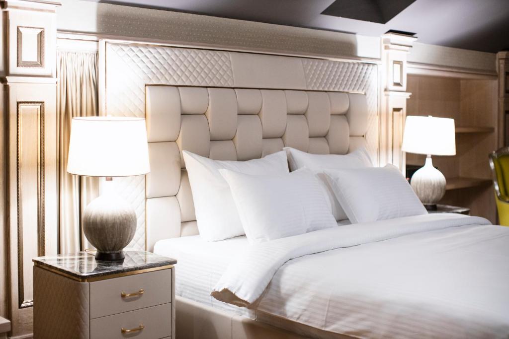 贝尔格莱德Eclat Luxury Rooms的卧室配有带两盏灯的白色床