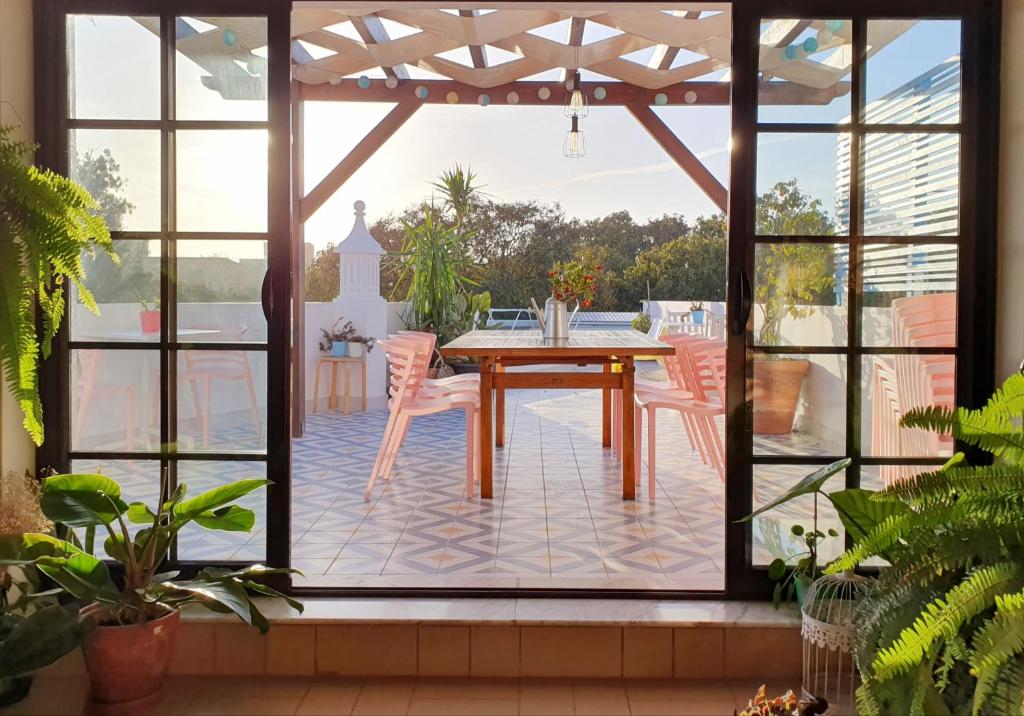 法鲁阳光之家酒店的庭院设有木桌、椅子和大窗户。