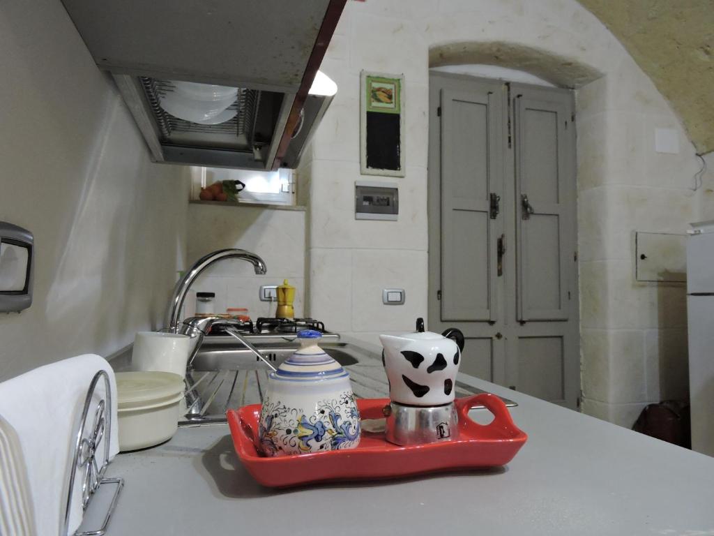 莫托拉Casa Charme Rotonda的厨房里装有红色的托盘,上面装有茶壶