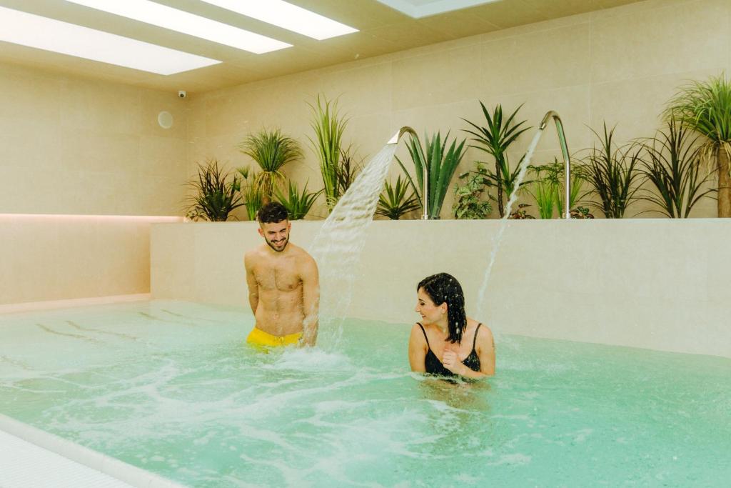 霍德梅泽瓦沙海伊金客阁酒店的游泳池里的男人和女人