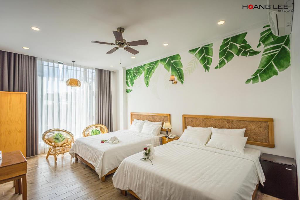 Phường SáuViva Hotel Phú Yên的酒店客房配有两张床和吊扇。