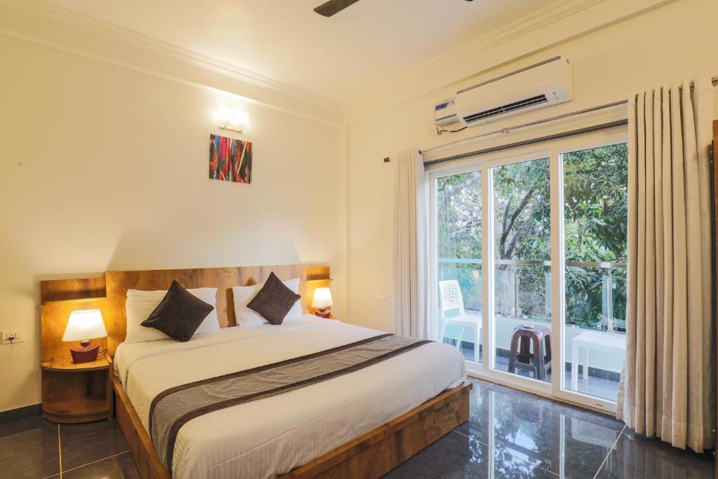 阿姆波尔Aaria Residency的一间卧室设有一张床和一个大窗户