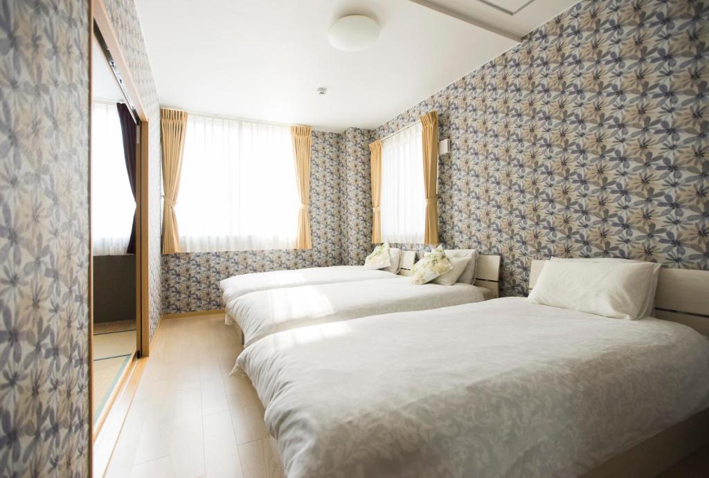 大阪guest house Sora的酒店客房内的一排床位