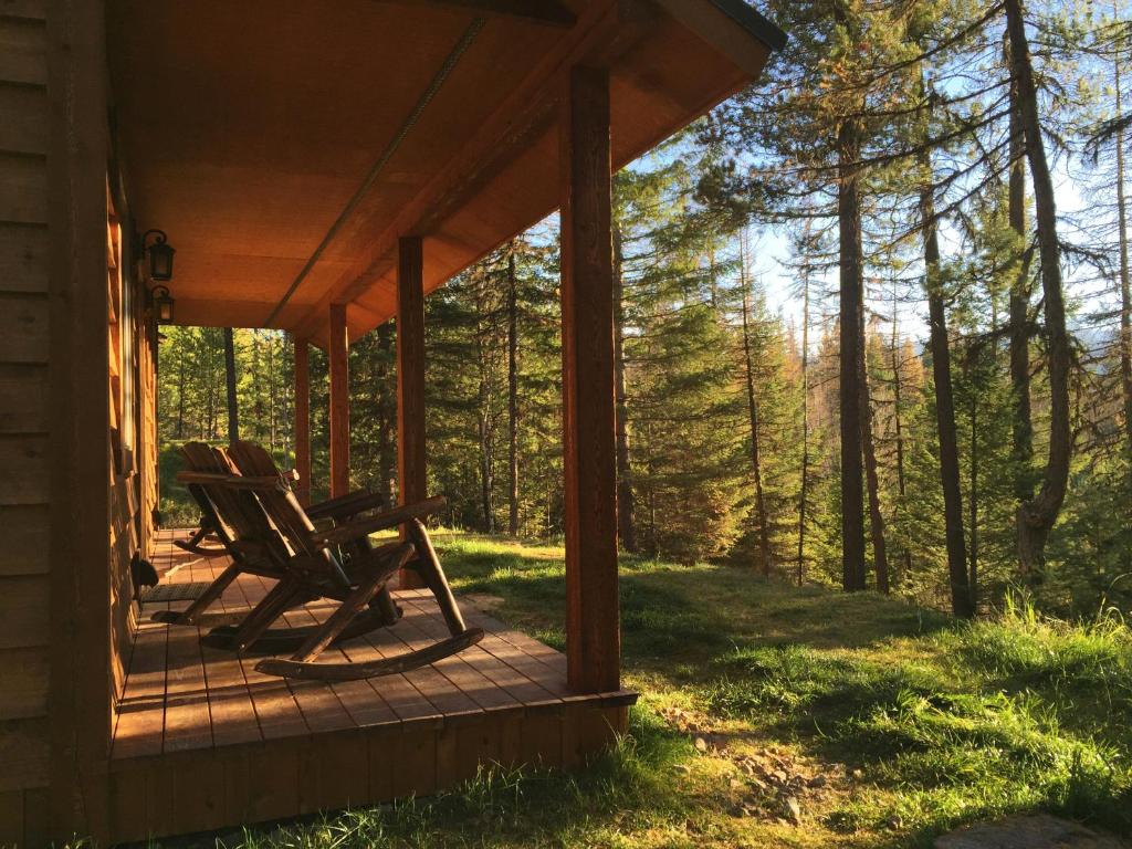 CoramThe Ridge At Glacier - Luxury Cabins的树林小屋门廊上的摇椅