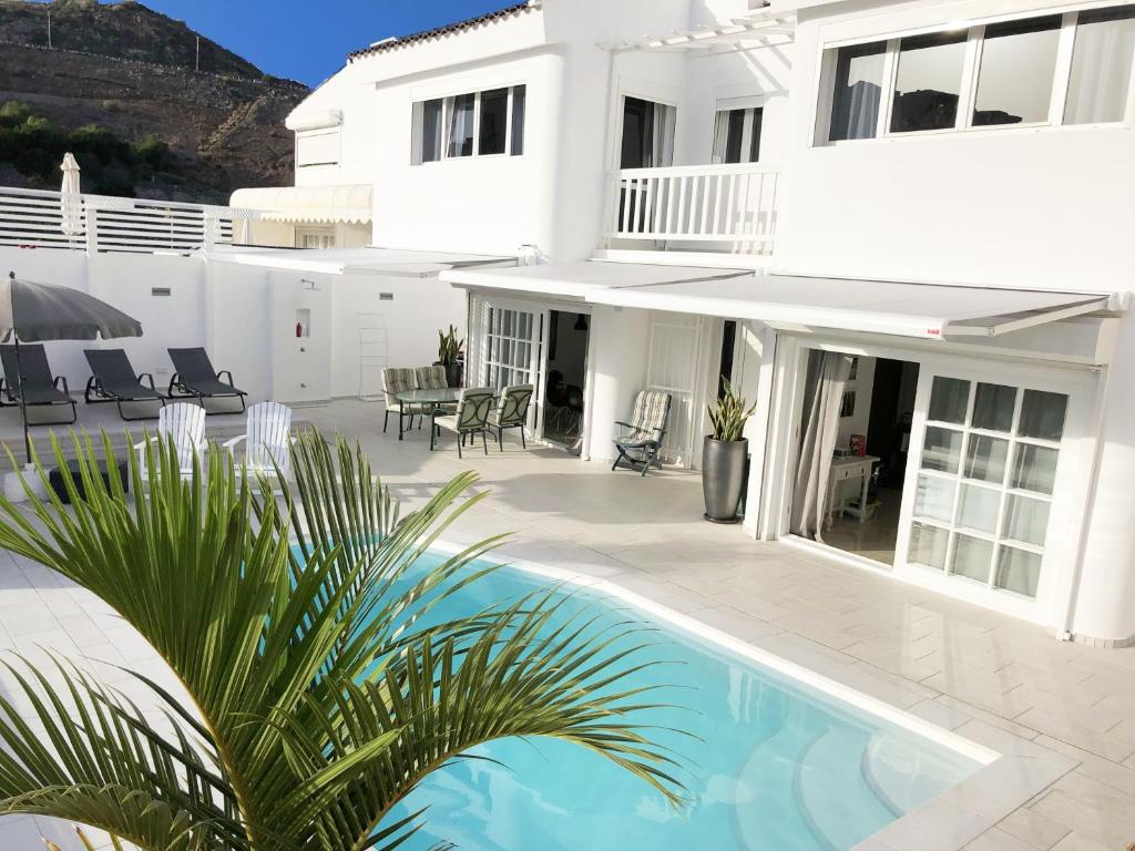 圣阿古斯丁Sea view villa San Agustin的一座白色的房子,前面设有一个游泳池