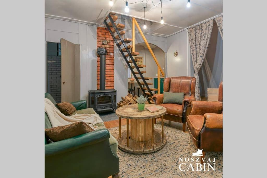 诺茨瓦约Noszvaj Cabin的带沙发和桌子的客厅以及楼梯