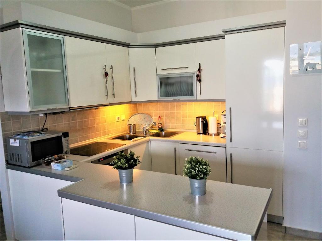 波塔莫斯Potamos apartment with view的厨房配有白色橱柜和台面