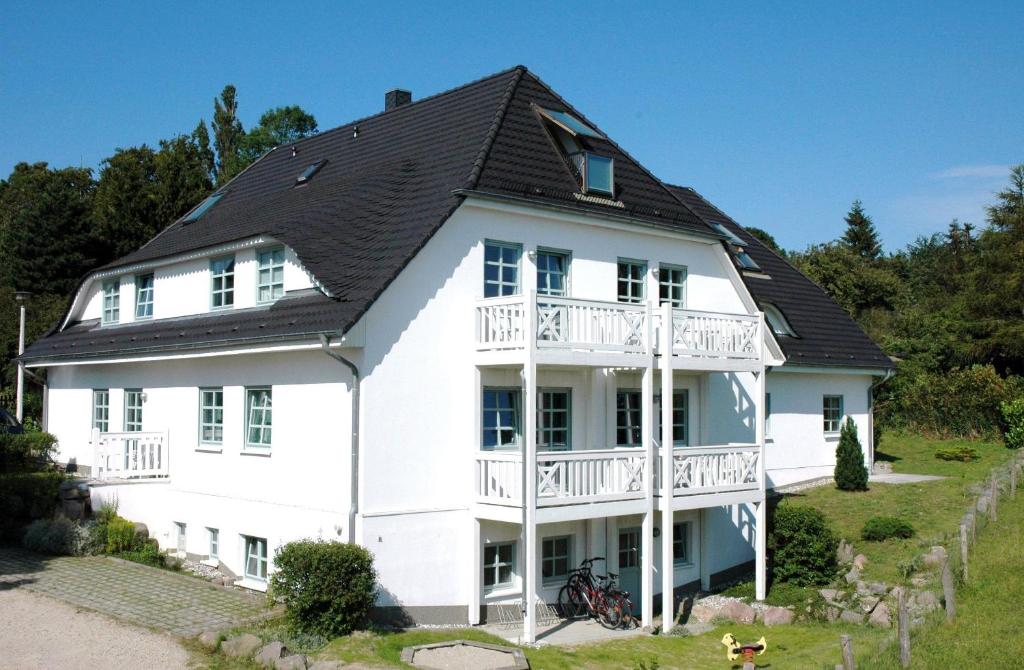 奥斯特巴德·哥伦Ferienhaus-mit-Schwimmbad-Sauna的黑色屋顶的大型白色房屋
