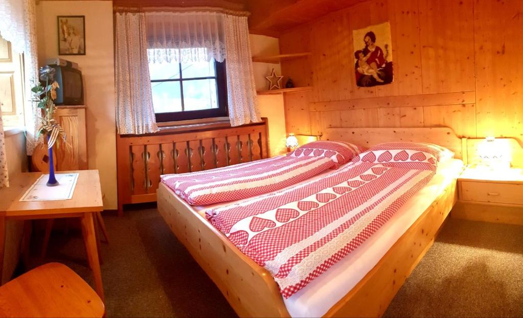 艾奇Mühlnerhof Familie Gruber的木制客房内的一间卧室,配有一张床