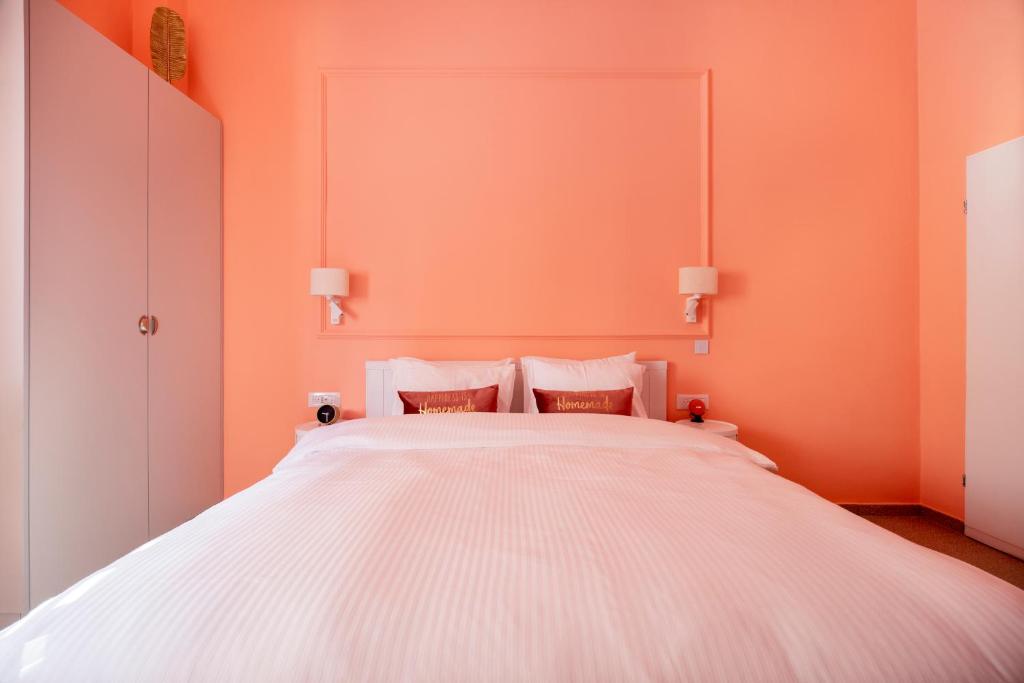 特拉维夫Glamorous Pink Pearl Studio/Beach/Parking/Netflix的卧室配有白色大床和橙色墙壁