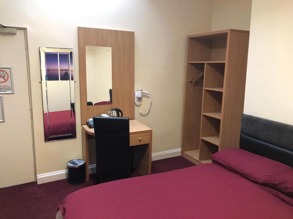 谢菲尔德Don Valley hotel Sheffield arena的客房设有一张床、一张书桌和一面镜子