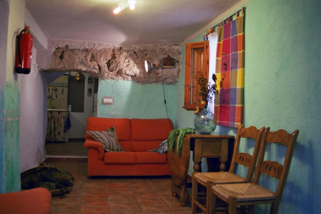 莱图尔Casa Rural Albayacín的客厅配有橙色沙发和桌子
