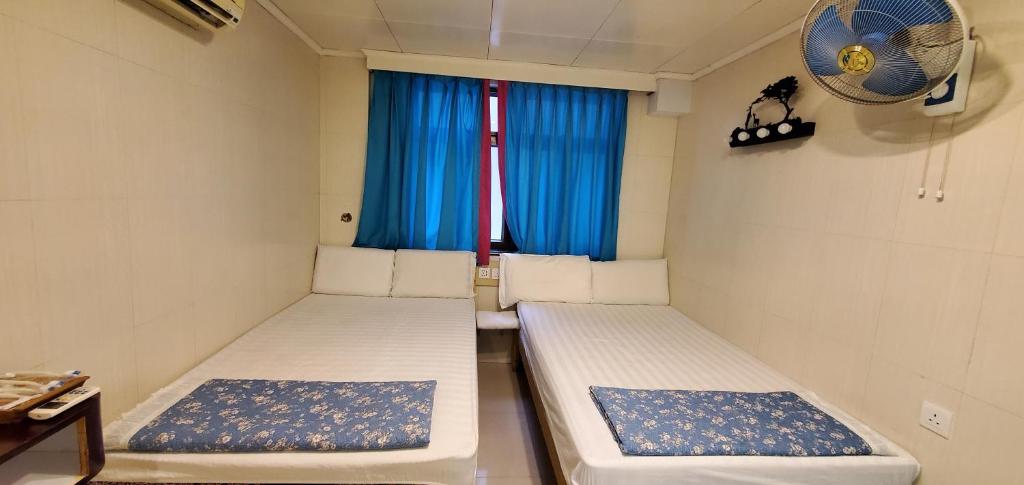 香港New hoover hostel的小型客房 - 带2张床和窗户