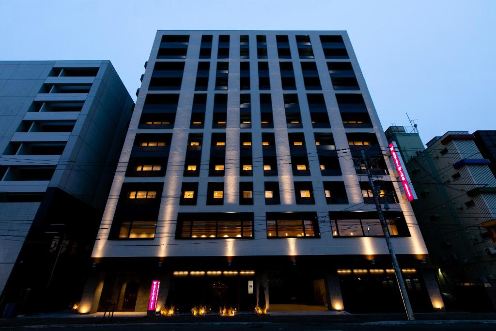 札幌Hotel Wing International Sapporo Susukino的一座高大的建筑,有明亮的窗户