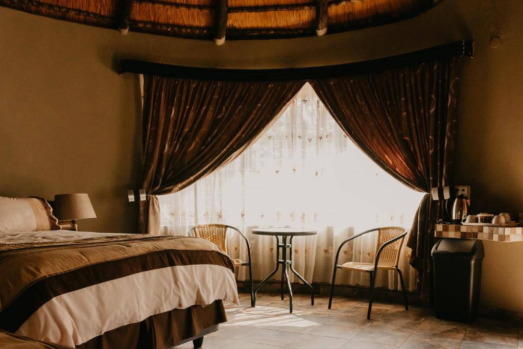 内尔斯普雷特Mabalel Lodge的一间卧室配有一张床,窗户配有桌子