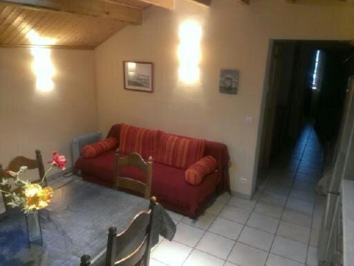 Saint-Martin-en-VercorsGîte La Morandière的客厅配有红色的沙发和桌子
