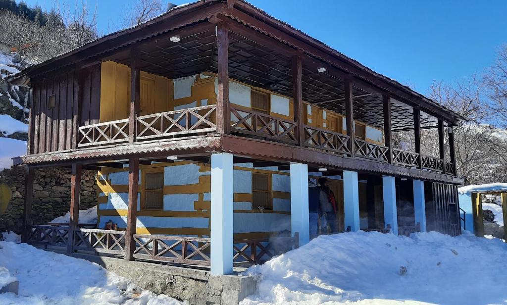 HarsilMountain Village Stay - Dharali Heights Harsil的雪中积雪的建筑物