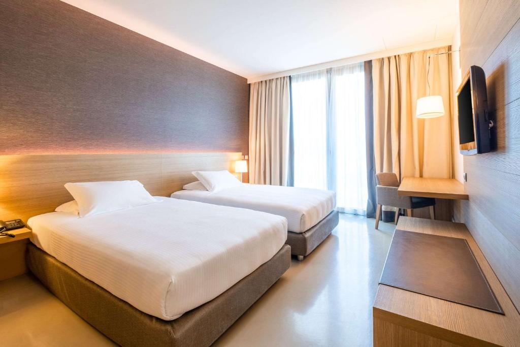 格巴格南特莫纳斯特尔圣马蒂诺品质酒店的酒店客房设有两张床和电视。