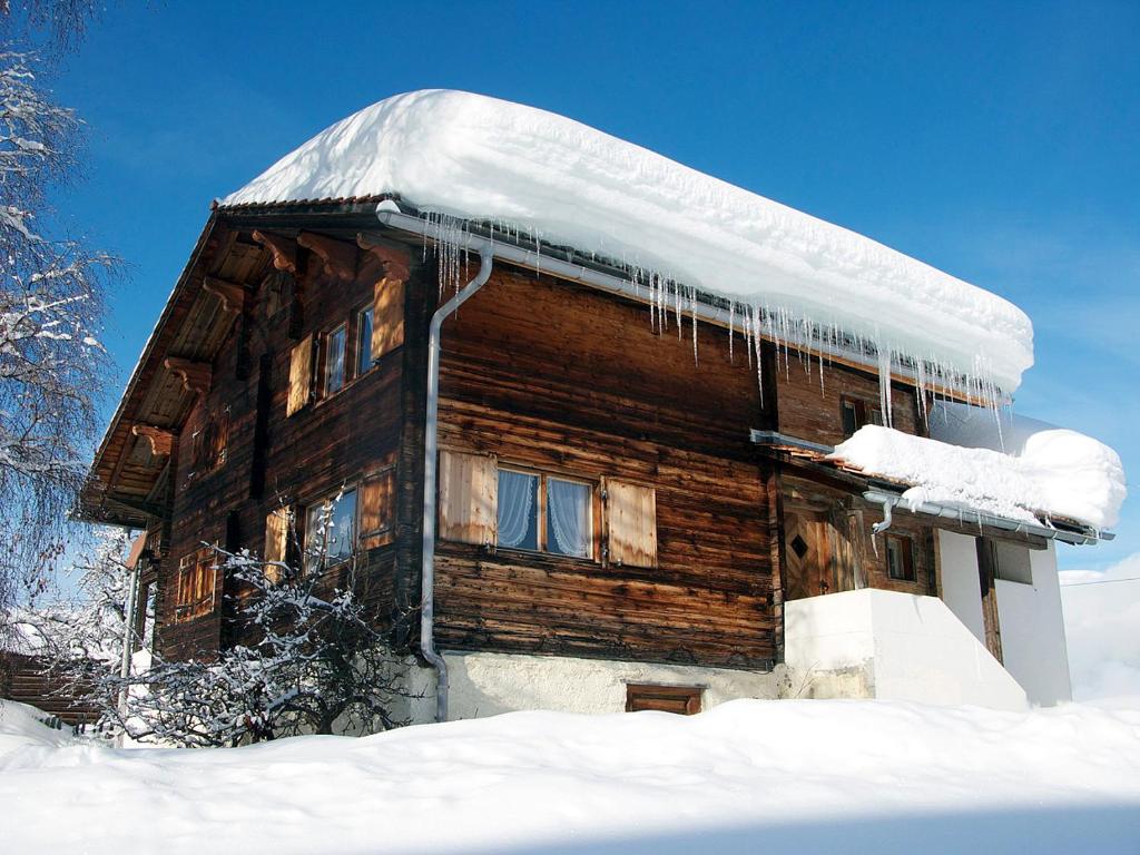 上萨克森Casa Cadruvi, Ferienhaus in Obersaxen, 150 Quadratmeter的雪中挂着冰壶的小木屋
