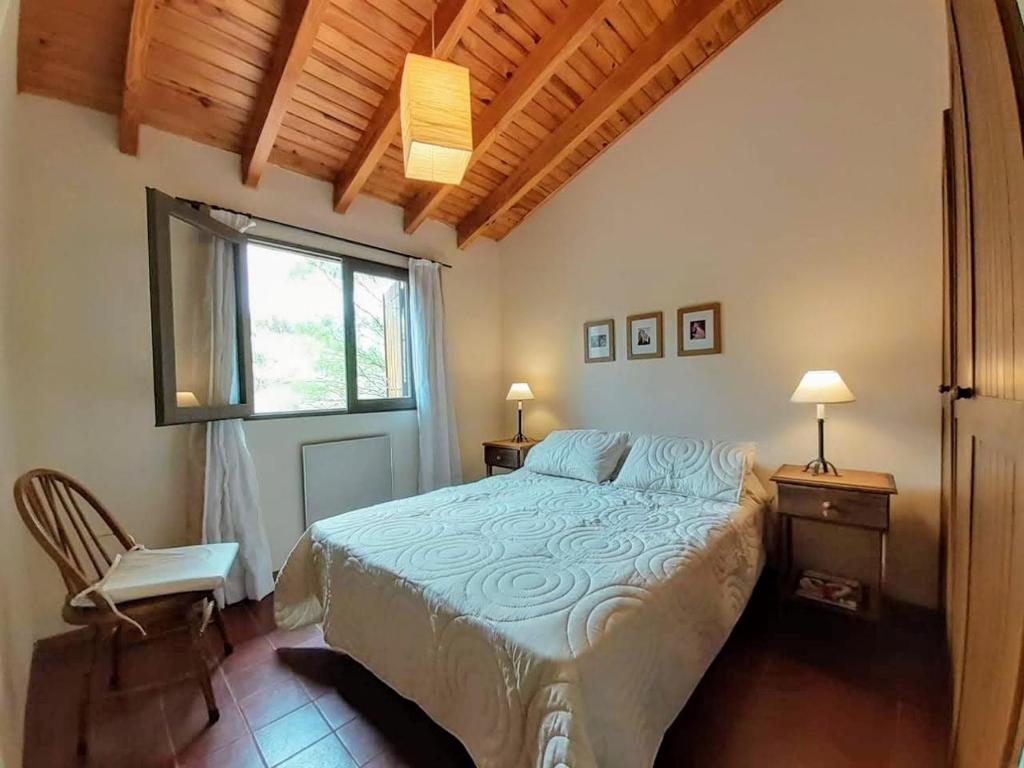 波特雷里约斯Remanso de las Acacias - Potrerillos的一间卧室设有一张床和一个窗口
