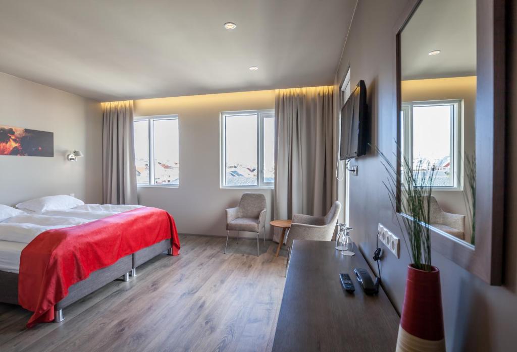 韦斯特曼纳埃亚尔韦斯特曼伊雅尔酒店的酒店客房,配有一张带红色毯子的床