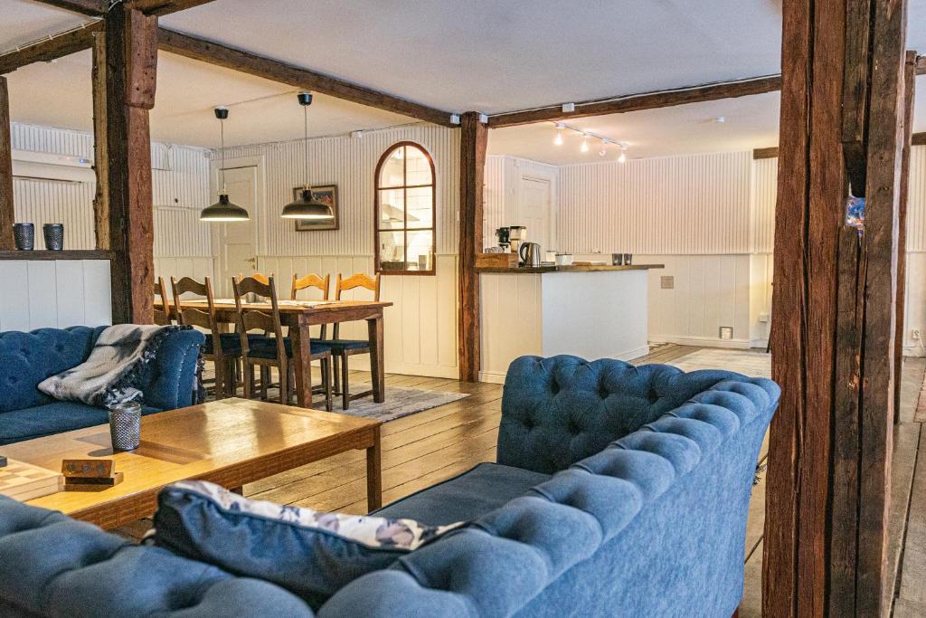 EnhörnaLadugårdens Pub & Sal的客厅配有2张蓝色的沙发和1张桌子