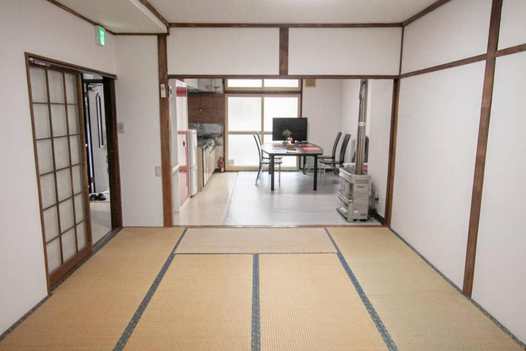 小樽Otaru Katsunai House的一间带桌子的房间和一间用餐室