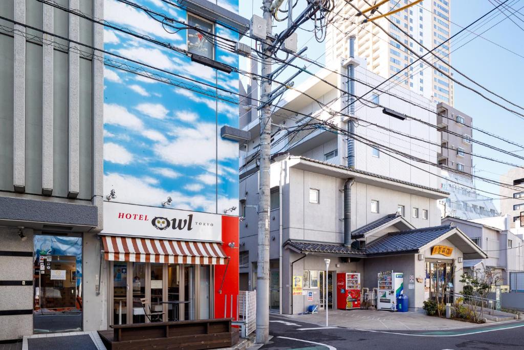 东京东京日暮里奥维力胶囊旅馆的一条城市街道,有建筑物和电源线