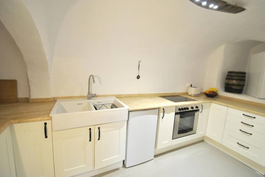 Éxo GoniáCavern House Helios的厨房配有白色橱柜和水槽