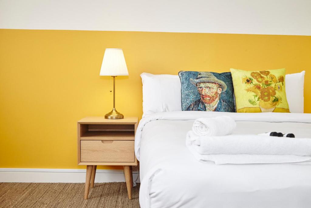 悉尼The Erko Hotel的一间卧室配有一张黄色墙壁的床