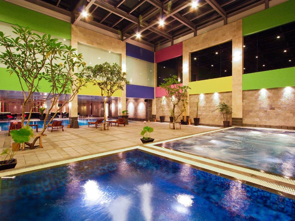 当格浪FM7度假酒店 - 雅加达机场的植物群中的一座大型游泳池