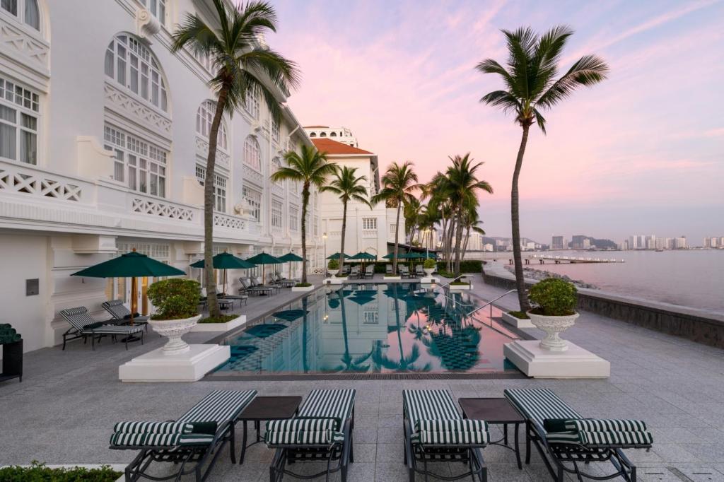 乔治市依恩奥酒店的酒店游泳池拥有棕榈树和桌椅
