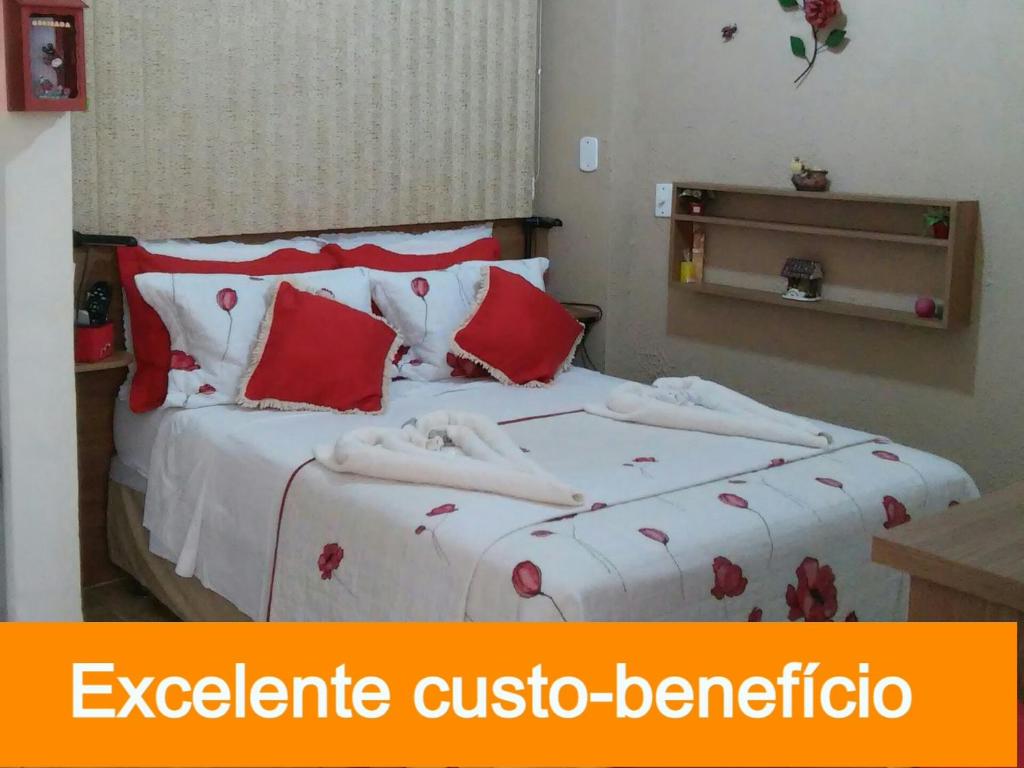 卡尚布Apart Hotel em Caxambu207的一间卧室配有红色和白色床单
