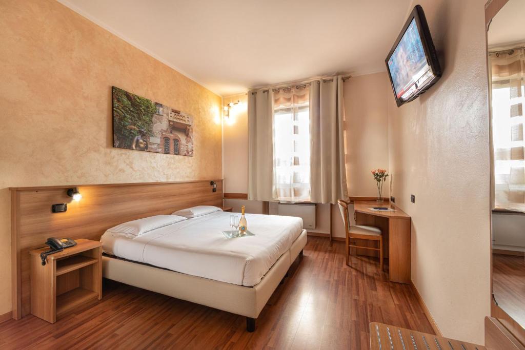 多索博诺波斯图米亚酒店的酒店客房设有一张床和墙上的电视