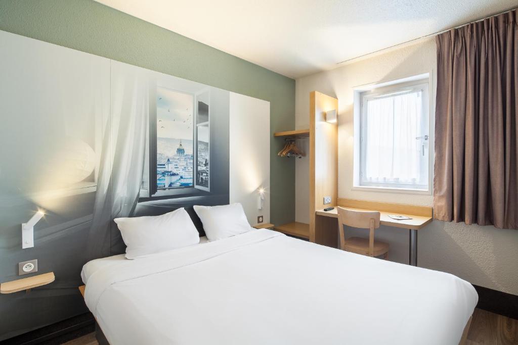 奥尔日河畔圣米歇尔B&B HOTEL Saint-Michel sur Orge的一间设有大床和窗户的酒店客房