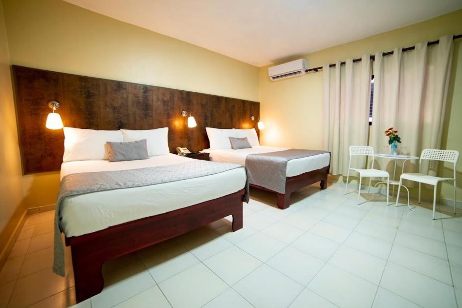圣多明各里尔贝拉维斯塔酒店的酒店客房设有两张床和一张桌子。
